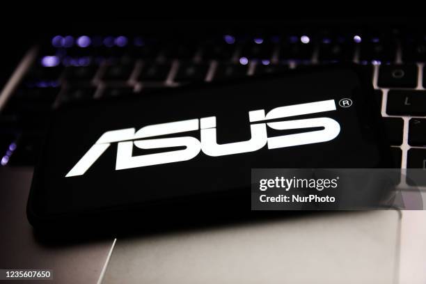 Asus logo displayed on a phone screen and laptop keyboard are seen in this illustration photo taken in Krakow, Poland on September 30, 2021.