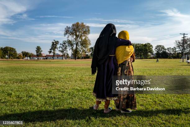 Afghan refugee girls watch a soccer match near where they are staying in the Village at the Ft. McCoy U.S. Army base on September 30, 2021 in Ft....