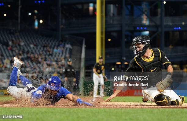 Rafael Ortega of the Chicago Cubs steals home plate ahead of a tag attempt by Jacob Stallings of the Pittsburgh Pirates in the second inning during...