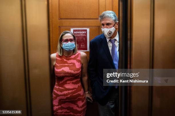 Sen. Kyrsten Sinema and Sen. Joe Manchin catch and an elevator to go to the Senate Chamber to vote, after meeting in Sen. Manchins hideaway for half...