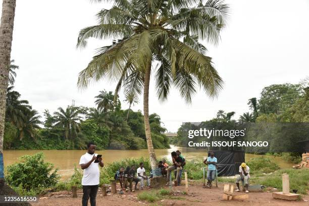 Residents in the town of Noe stand near the Ghana and Ivory Coast where the border is closed due to COVID-19 pendemic on September 22, 2021 - Life...