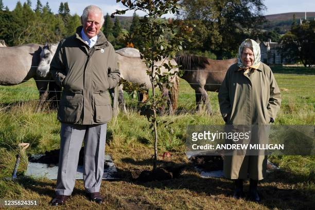 Britain's Queen Elizabeth II and Britain's Prince Charles, Prince of Wales pose alongside the tree which they planted to mark the start of the...