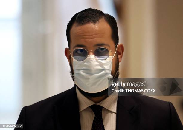 French President Emmanuel Macron's former bodyguard Alexandre Benalla, wearing a mask, arrives for trial in Paris on October 1 for an alleged assault...