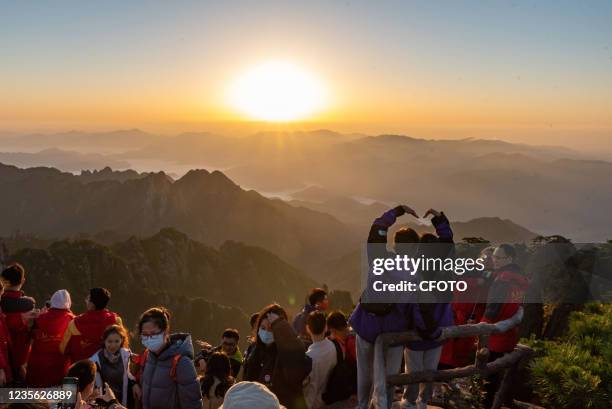 Tourists watch the sunrise at Huangshan Scenic Area in Huangshan City, East China's Anhui Province, Oct 1, 2021.