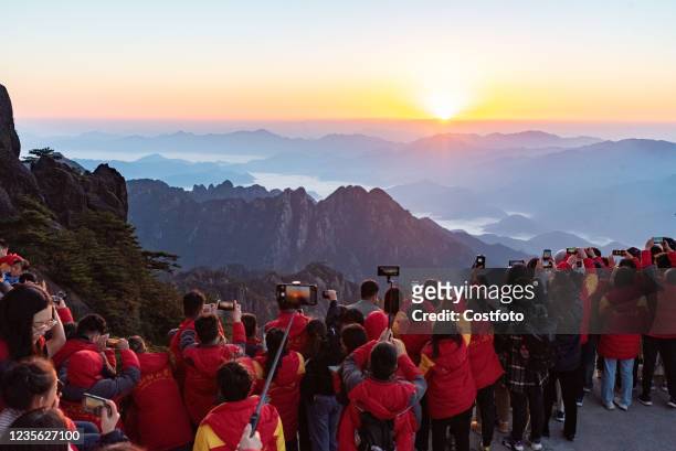 Tourists watch the sunrise at Huangshan Scenic Area in Huangshan City, East China's Anhui Province, Oct 1, 2021.