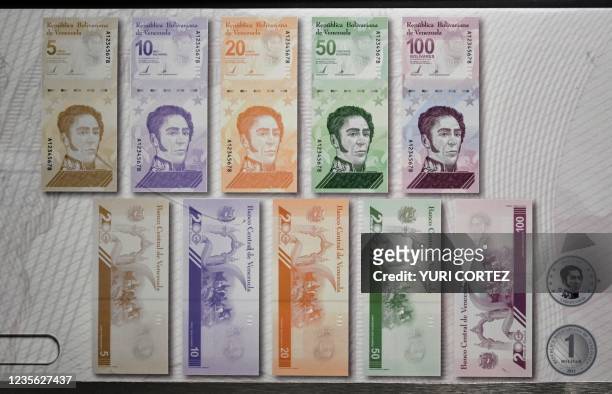 Printed poster showing the new banknotes put in circulation by the Central Bank of Venezuela as part of the currency conversion is seen in a bank in...