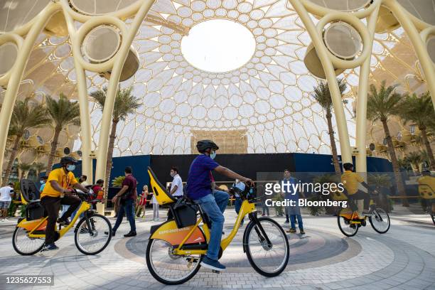 Visitors ride bicycles on the opening day of the Expo 2020 exhibition in Dubai, United Arab Emirates, on Friday, Oct. 1, 2021. Having spent years...