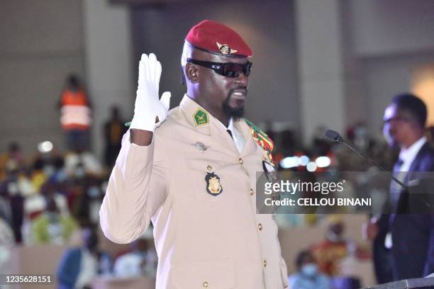Guinea junta leader Colonel Mamady Doumbouya, raises his hand at his swearing in ceremony as president of country transion on October 1, 2021 in...