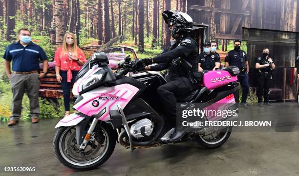 Burbank Police officer Ryan Johnson rides a pink police motorcycle during an event for breast cancer awarenwess month of October in Burbank,...