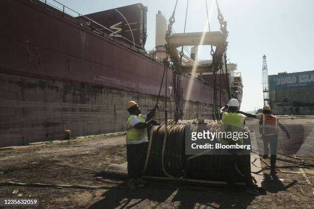 Workers unload bar-in-coil steel from a freight ship in the dockyard at the Port of Detroit in Detroit, Michigan, U.S., on Monday, Sept. 27, 2021....