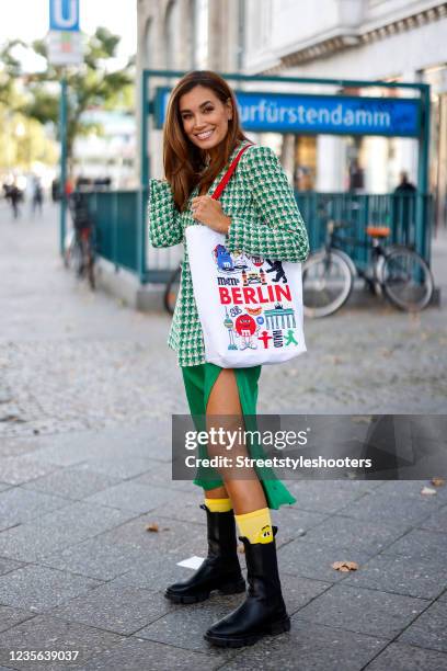 Jana Ina Zarrella wearing a green and white blazer by Zara, a green dress with leg slit by Zara, black boots by Copenhagen, yellow socks by M&MS and...