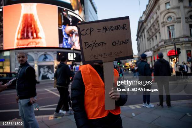 Protester holds a placard calling the public to boycott the Communist Party in China during the protest. Hongkongers, Tibetans and Uyghurs...