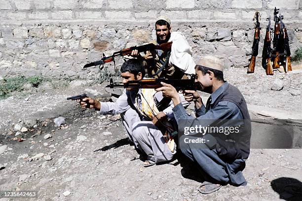Afghan anti-Soviet resistance mujahideens armed with Egyptian copy of Soviet Kalashnikov assault rifle train on August 15, 1980 in a camp in...