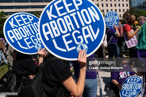 Women rights activists hold up signs as they gather at Freedom Plaza for a pre-march rally of the annual Womens March October 2, 2021 in Washington,...