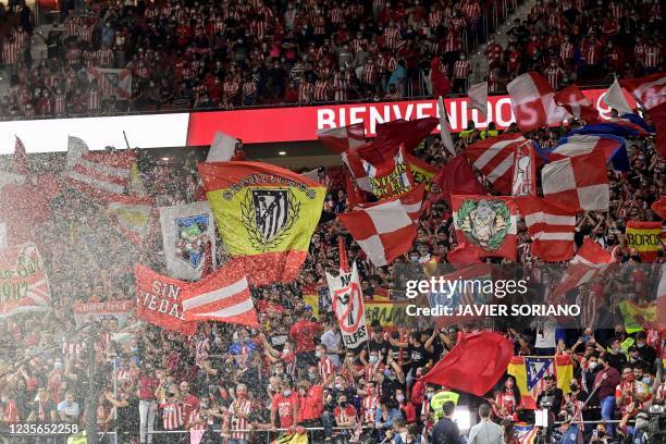 Supporters cheer before the start of the Spanish League football match between Club Atletico de Madrid and FC Barcelona at the Wanda Metropolitano...