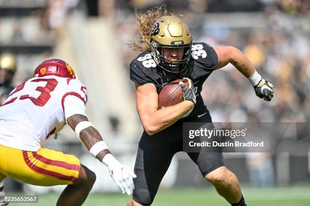 Tight end Brady Russell of the Colorado Buffaloes carries the ball against cornerback Joshua Jackson Jr. #23 of the USC Trojans after a catch in the...