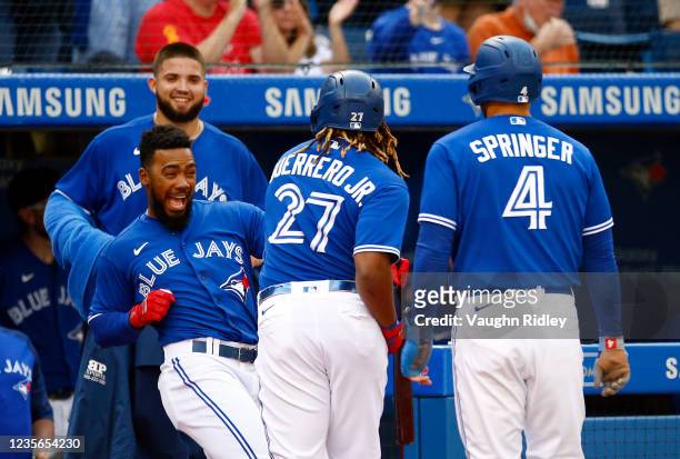 Vladimir Guerrero Jr. #27 of the Toronto Blue Jays celebrates with Teoscar Hernnadez after hitting a two-run home run in the first inning during a...