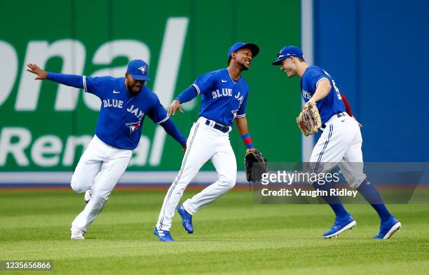 Teoscar Hernandez, Jarrod Dyson and Randal Grichuk of the Toronto Blue Jays celebrate the win following a MLB game against the Baltimore Orioles at...