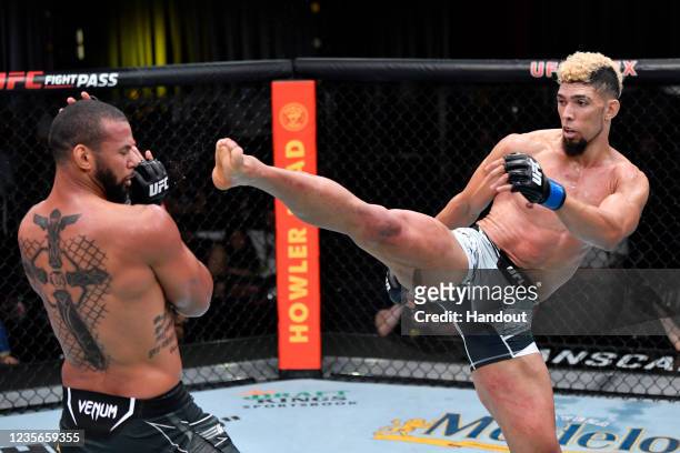 In this handout photo provided by UFC, Johnny Walker of Brazil kicks Thiago Santos of Brazil in their light heavyweight bout during the UFC Fight...