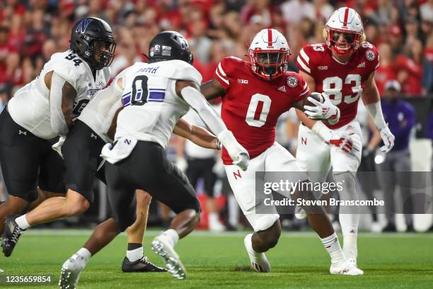 Running back Jaquez Yant of the Nebraska Cornhuskers runs the ball against defensive back Coco Azema of the Northwestern Wildcats in the first half...