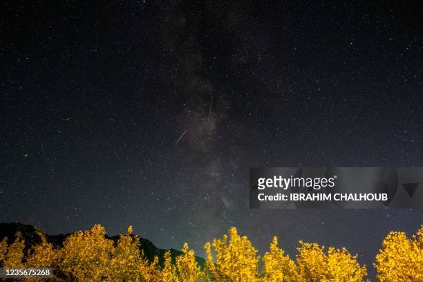 Meteors of the Orionid meteor shower streak as they cross through the milkyway in the mountainous area of Tannourine in northern Lebanon, on October...