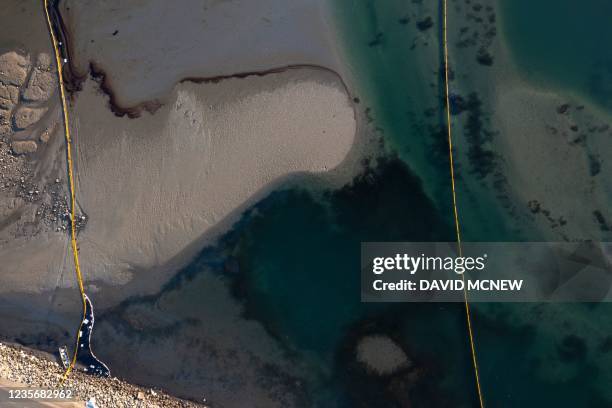 This aerial picture taken on October 3, 2021 shows oil and an oil containment booms in the water of the Talbert Marshlands area from an offshore oil...