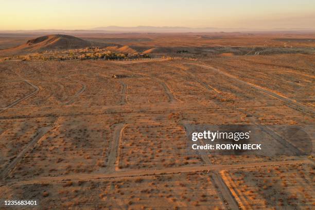 This aerial picture taken on October 2, 2021 shows the sun rising over a vast network of roads cut in the Mojave Desert, intended for a massive...