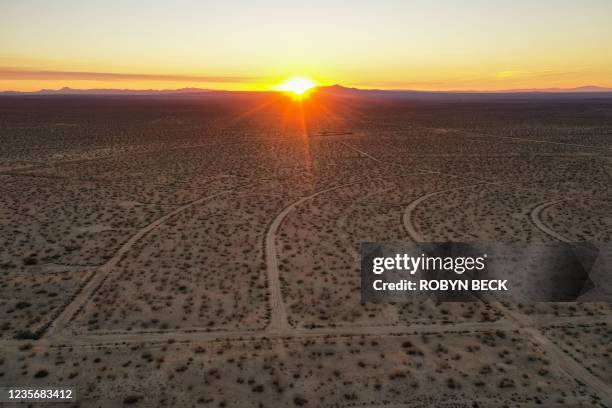 This aerial picture taken on October 2, 2021 shows the sun rising over a vast network of roads cut in the Mojave Desert, intended for a massive...