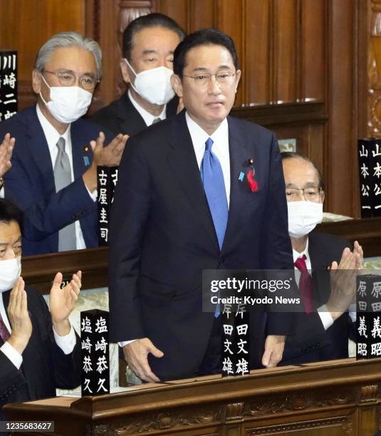 Fumio Kishida , the new leader of Japan's ruling Liberal Democratic Party, stands up after being elected prime minister during a House of...