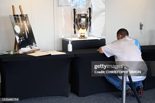 Well-wisher pauses in front of The European Champions League football trophy, after signing a book of condolence at Stade Velodrome in Marseille,...