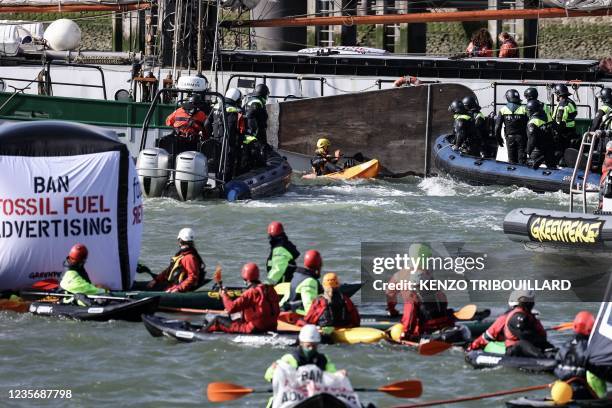 Activists of the environmental NGO Greenpeace try to stop a police ship as they block the port of Dutch oil company Shell's refinery on Pernis site...