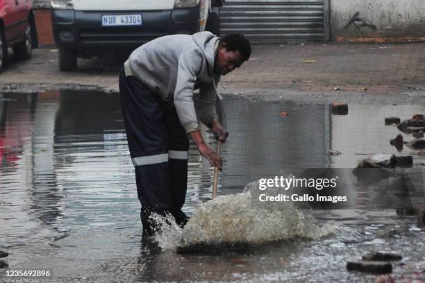 Man clears out excess water during Vooma Vaccination Campaign on October 03, 2021 in Durban, South Africa. This is part of the government's efforts...