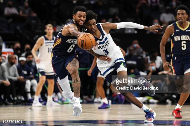 Nickeil Alexander-Walker of the New Orleans Pelicans and Jaden McDaniels of the Minnesota Timberwolves compete for the ball in the fourth quarter of...