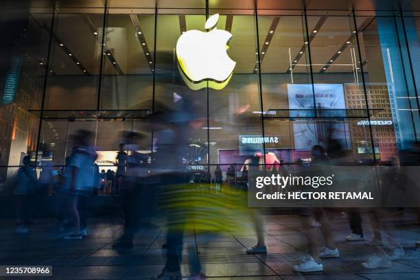People walk past an Apple store in Shanghai on October 5, 2021.