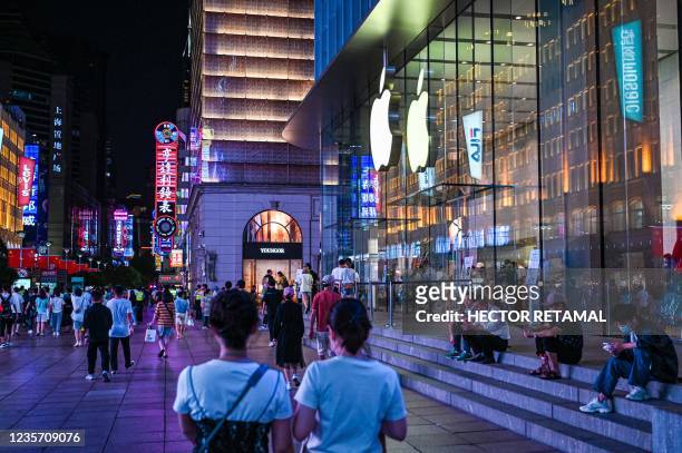 People walk past an Apple store in Shanghai on October 5, 2021.