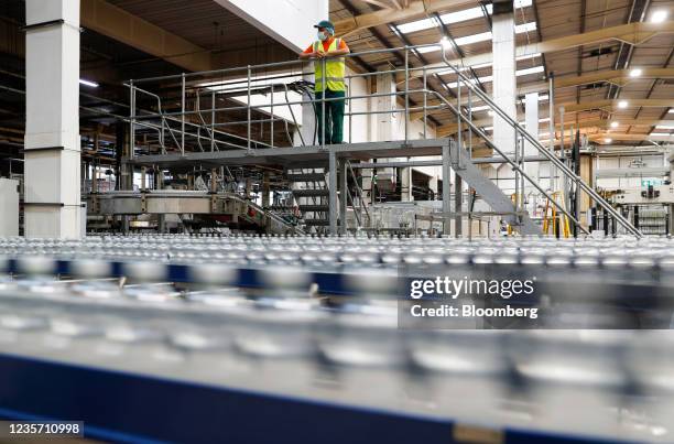 Worker looks over bottles of tonic water on the production line at the Refresco soft-drink bottling factory in Kegworth, U.K., on Tuesday, Oct. 5,...