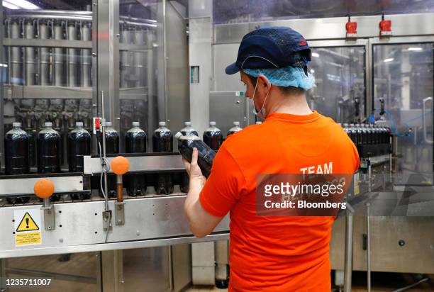 Worker checks a bottle of Dandelion and Burdock on the production line at the Refresco soft-drink bottling factory in Kegworth, U.K., on Tuesday,...
