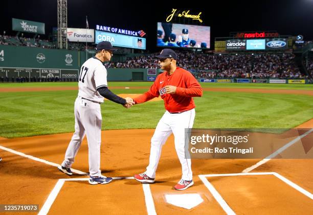 Alex Cora of the Boston Red Sox and Aaron Boone of the New York Yankees shake hands prior to the game at Fenway Park on Tuesday, October 5, 2021 in...
