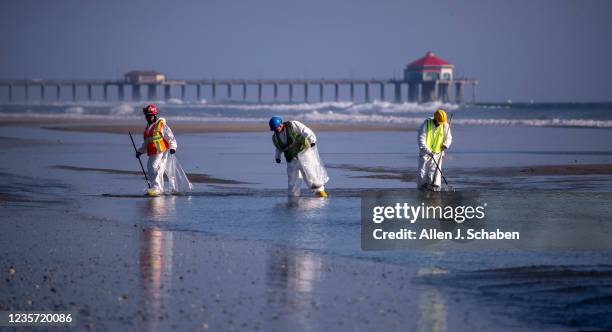 Huntington Beach, CA Environmental oil spill cleanup crews clean oil chucks off the beach from a major oil spill in Huntington Beach Tuesday, Oct. 5,...