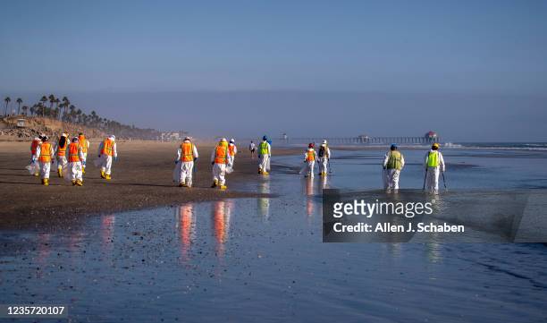 Huntington Beach, CA Environmental oil spill cleanup crews clean oil chucks off the beach from a major oil spill in Huntington Beach Tuesday, Oct. 5,...