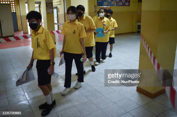 Thai student wait to be administered a dose of the Pfizer vaccine for the Covid-19 coronavirus at Surasak Montree School in Bangkok on October 6,...