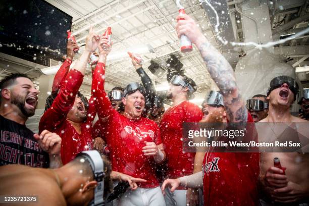 Members of the Boston Red Sox celebrate with champagne in the clubhouse after winning the 2021 American League Wild Card game against the New York...