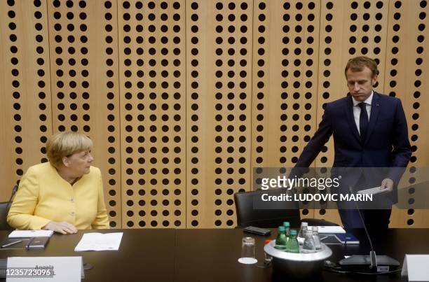Germany's Chancellor Angela Merkel and France's President Emmanuel Macron react during the EU-Western Balkans summit at Brdo Congress Centre, near...