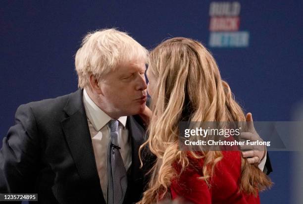 Britain's Prime Minister Boris Johnson kisses wife Carrie Johnson after delivering his keynote speech during the Conservative Party conference at...