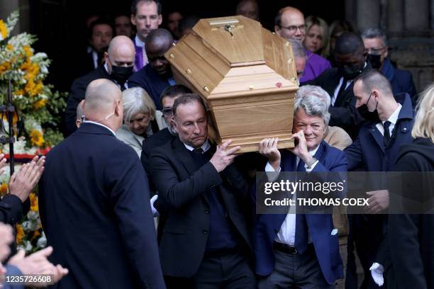 French former football player Jean-Pierre Papin and French politician Jean-Louis Borloo carry the coffin after a mass for late French business...