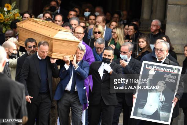 French former football player Jean-Pierre Papin and French politician Jean-Louis Borloo carry the coffin after a mass for late French business...