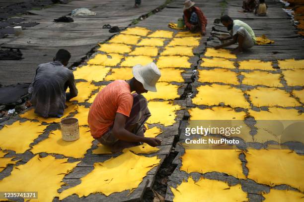 Workers set up leather pieces on a rack to make it dry at a tannery in Hazaribag, Dhaka, Bangladesh on October 06, 2021. Though many leather...