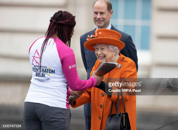 Queen Elizabeth II presents the baton to British Paralympic athlete Kadeena Cox during the Baton Relay for Birmingham 2022, the XXII Commonwealth...