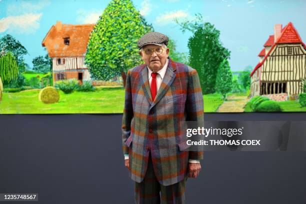 British painter David Hockney poses at the Orangerie museum in Paris, on October 7 in front of his painting "A year in Normandy", a 91-meter-long...