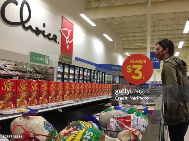 Woman looks at frozen turkeys at a supermarket a few days before the Thanksgiving long weekend during the fourth wave of the novel coronavirus...